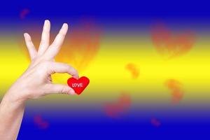 hand holding heart-shaped on background photo