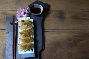 fried dumplings or gyoza on wood background photo