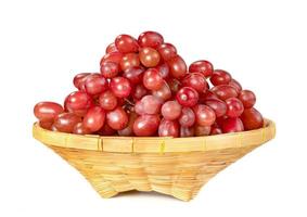 red seedless grapes in the basket isolated on white background photo