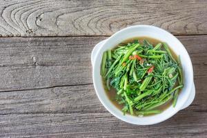 revuelva las espinacas de agua frita o pak boong fai daeng en un plato blanco foto