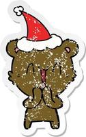 happy bear distressed sticker cartoon of a wearing santa hat vector