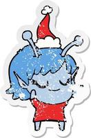 smiling alien girl distressed sticker cartoon of a wearing santa hat vector