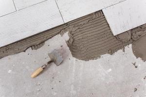 Ceramic wood effect tiles and tools for tiler on the floor photo