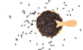 dark violet rice berry with wooden bowl and spoon isolated on white background photo