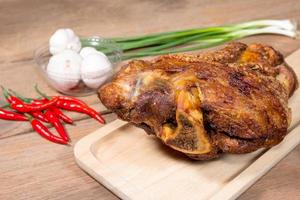 fried pork leg cooked on chopping block photo