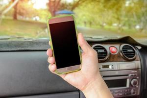 coche y mano humana sosteniendo un teléfono inteligente móvil en blanco foto