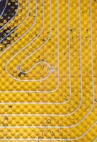 yellow underfloor heating installation with white pipes photo