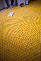 yellow underfloor heating installation with white pipes photo