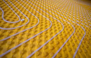 yellow underfloor heating installation with white pipes photo