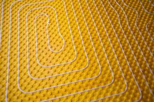 yellow underfloor heating installation with white pipes photo