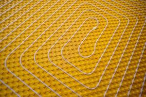 yellow underfloor heating installation with white pipes photo