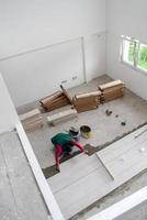 worker installing the ceramic wood effect tiles on the floor photo