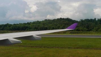 phuket, thaïlande 25 novembre 2018 - vue sur l'aéroport international de phuket depuis un avion au sol thai airways, airasia airbus a320 tourne sur la piste. video