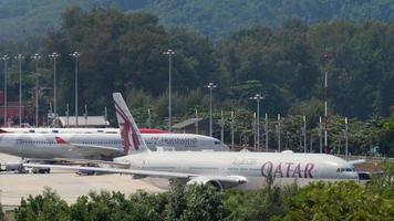 PHUKET, THAILAND NOVEMBER 30, 2019 - Qatar Airways Boeing 777 taxiing before departure and Airbus A330 Nordwind on service, Phuket intrnational airport. video