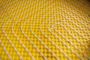 yellow underfloor heating installation with white pipes photo