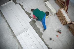 worker installing the ceramic wood effect tiles on the floor photo