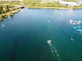 Beautiful Aerial Drone's Camera  Footage of Willen Lake and Park which is located at Milton Keynes, England. People are Enjoying at Lake on a Hot Sunny Day of Summer photo