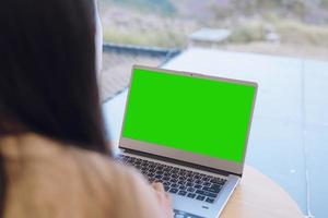 mujer jugando computadora pantalla verde computadora para diseño foto