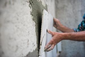 worker installing big ceramic tiles photo