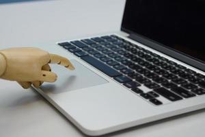 Selective focus of robot finger is using a laptop. Concept of artificial intelligence, technology and progress future. photo