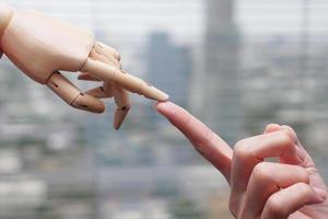 Human and wooden hands reach each other. Artificial intelligence, technology and progress future concept. photo