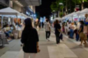 Blur background abstract people shopping night market street food festival defocused. photo