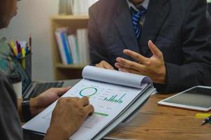 Business people meeting at the office by analyzing data from financial graphs and investment charts to plan a marketing team. photo