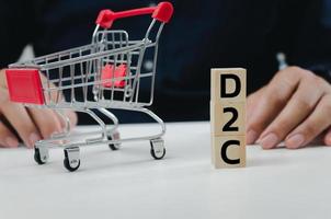 Wood cube block D2C symbol direct to consumer on table. photo