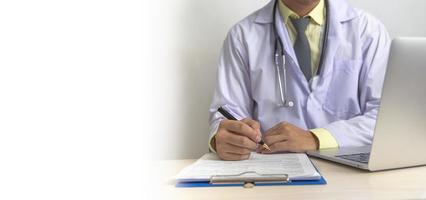 Doctor hand holding pen write and paperwork document patient treatment on clipboard.Business health care concept. photo