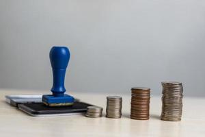 Rubber stamp and money coin stack business finance concept. photo