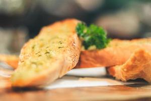 Close up Freshly baked garlic bread on wood plate. photo