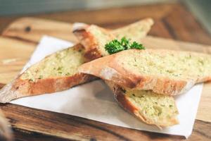 Close up Freshly baked garlic bread on wood plate. photo