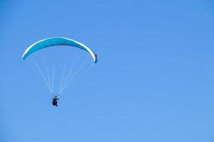 Paraglider soaring in the blue sky. photo