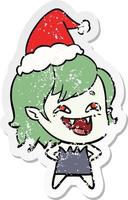 distressed sticker cartoon of a laughing vampire girl wearing santa hat vector