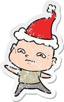 distressed sticker cartoon of a nervous man wearing santa hat vector
