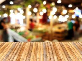 Wooden table with shopping mall blurred background photo