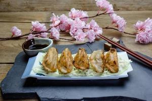 fried dumplings or gyoza on wood background photo