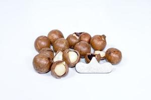 Open Macadamia nut by tool on background photo