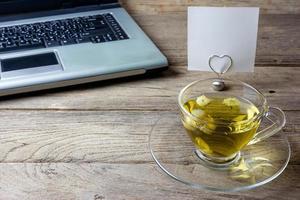 Chrysanthemum tea in a glass on wood background photo