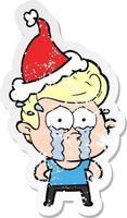 distressed sticker cartoon of a crying man wearing santa hat vector