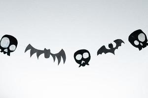 Bats and skulls black on white background, place to write greeting. photo