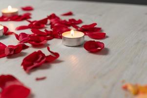 Scattered rose petals and candles, aromatic rose fragrance and candle aroma.