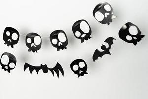 Bats and skulls black on white background, place to write greeting. photo