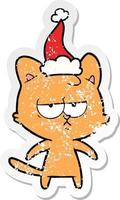 bored distressed sticker cartoon of a cat wearing santa hat vector