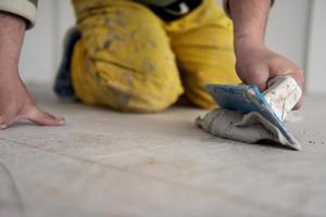 Tilers filling the space between ceramic wood effect tiles photo