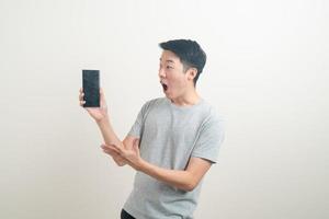 young Asian man using or talking smartphone and mobile phone photo