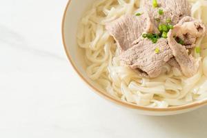 udon noodles with pork in clear soup photo