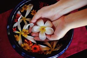 mano femenina y flor en agua foto