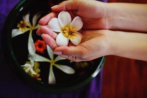 mano femenina y flor en agua foto