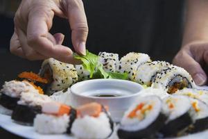 japanese sushi roll serving in oriental restaurant, chef is preparing japan tradition cookery menu, various different assorted luxury mixed healthy eating set concept photo